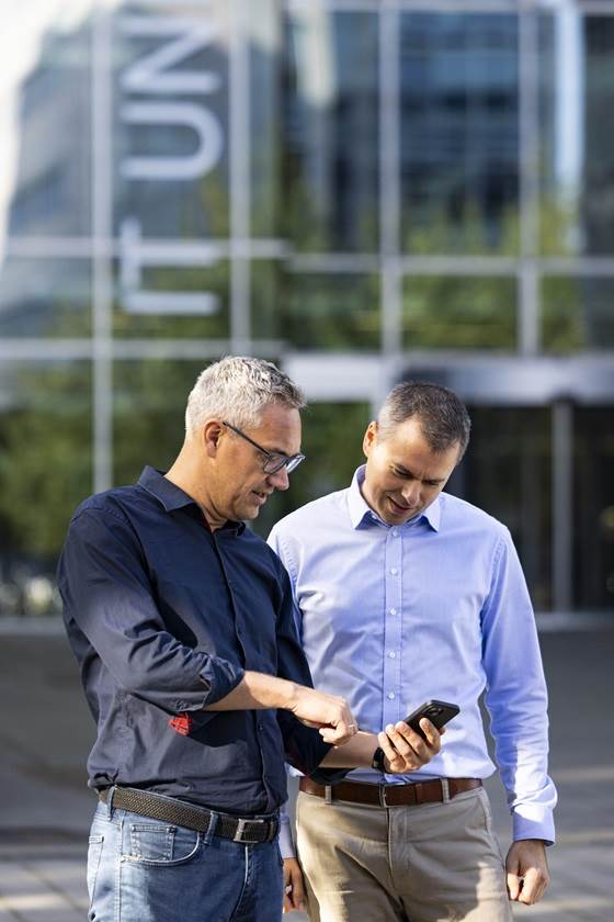 To mænd kigger på en telefon foran ITU