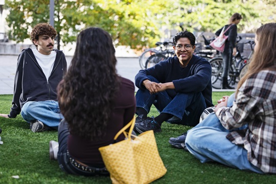 Studerende sidder på græsplænen